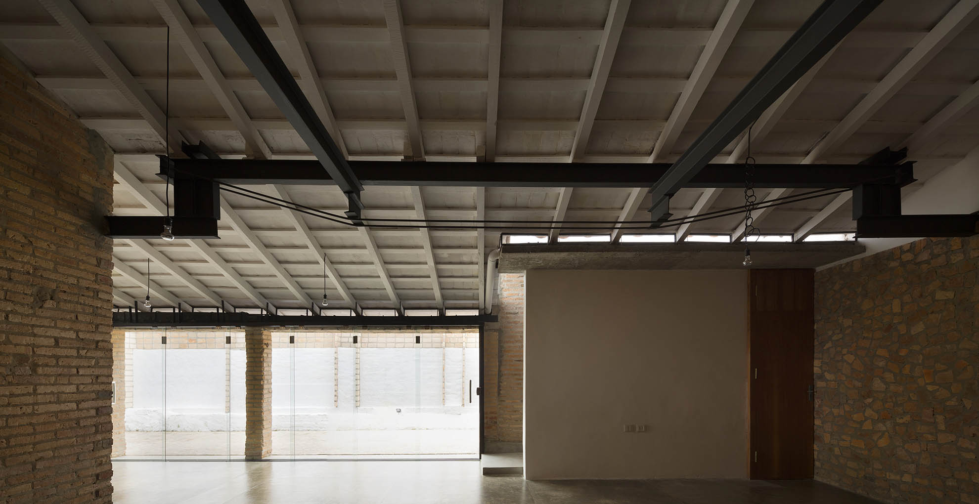 Interior de la Oficina Nordeste Curuguaty, donde la reutilización de materiales define la estructura y el diseño sostenible del espacio.