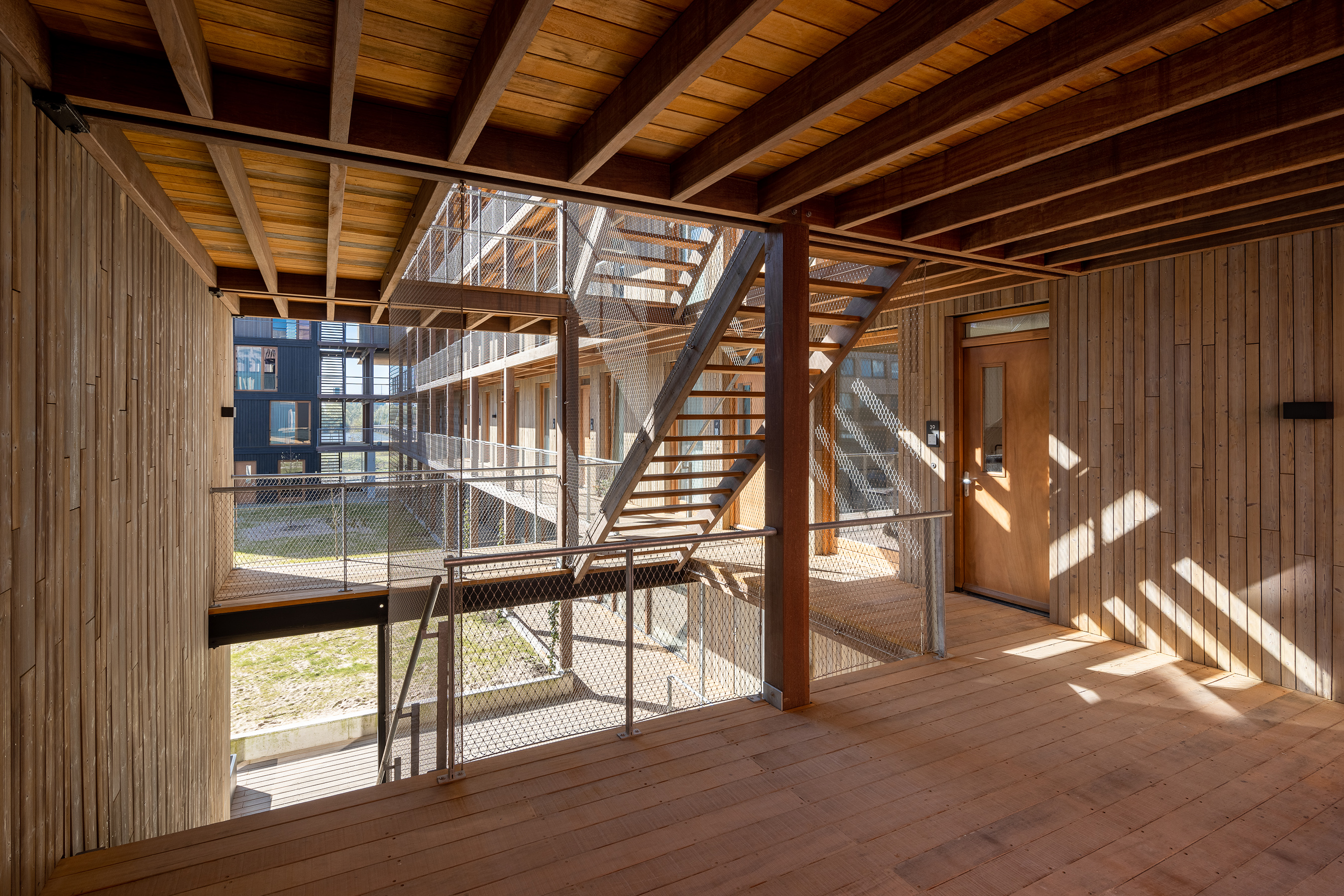 Interior del edificio Juf Nienke con estructura de madera que refleja el concepto de vivienda sostenible y diseño circular.