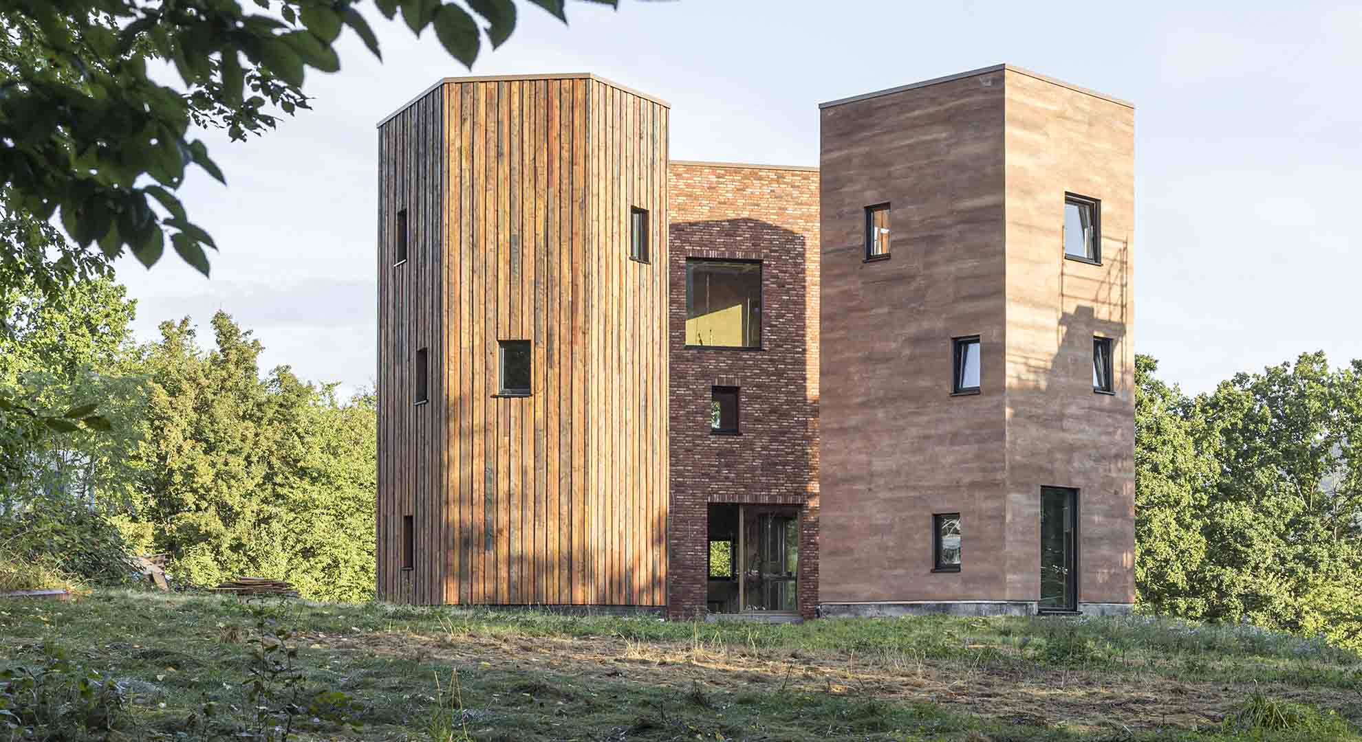 Edificio de diseño sostenible con materiales naturales, que fusiona arquitectura y sostenibilidad en un entorno verde.