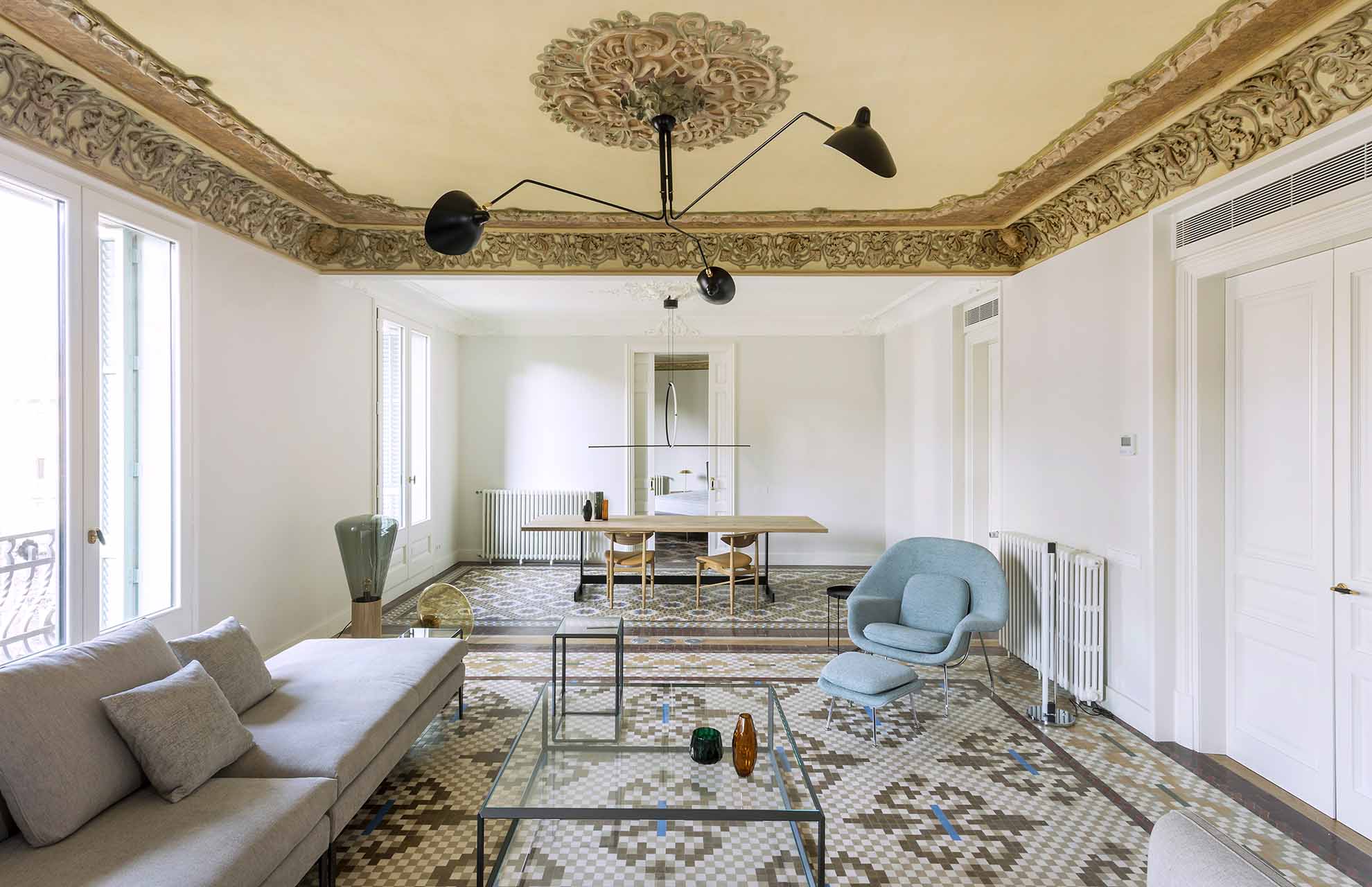 Interior de una vivienda rehabilitada en Barcelona con suelos de mosaico hidráulico y acabados que recuperan materiales tradicionales originales.