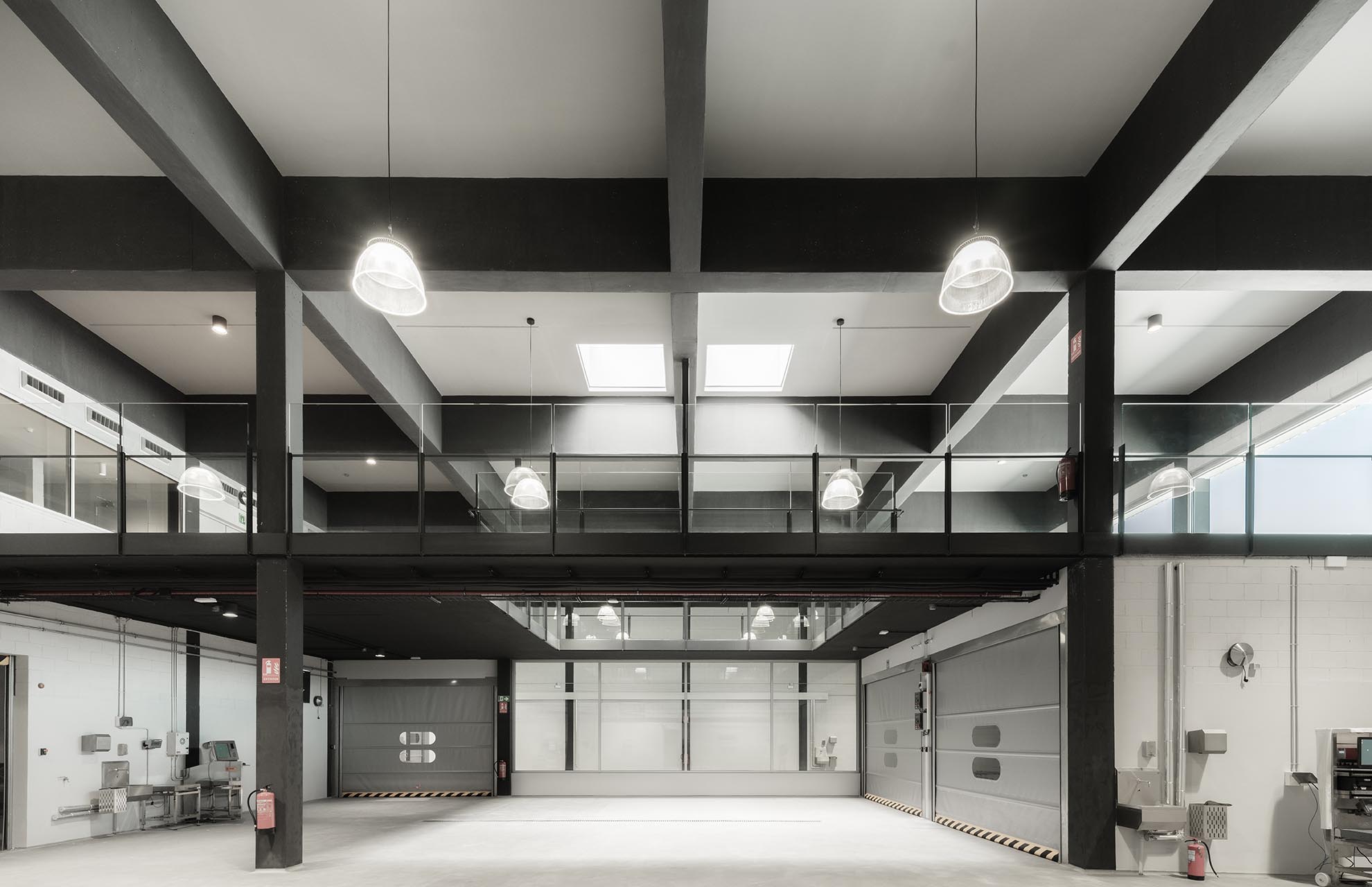 Functional interior of the Fish Market with exposed structure and suspended lighting, designed for durability and eco-conscious efficiency.