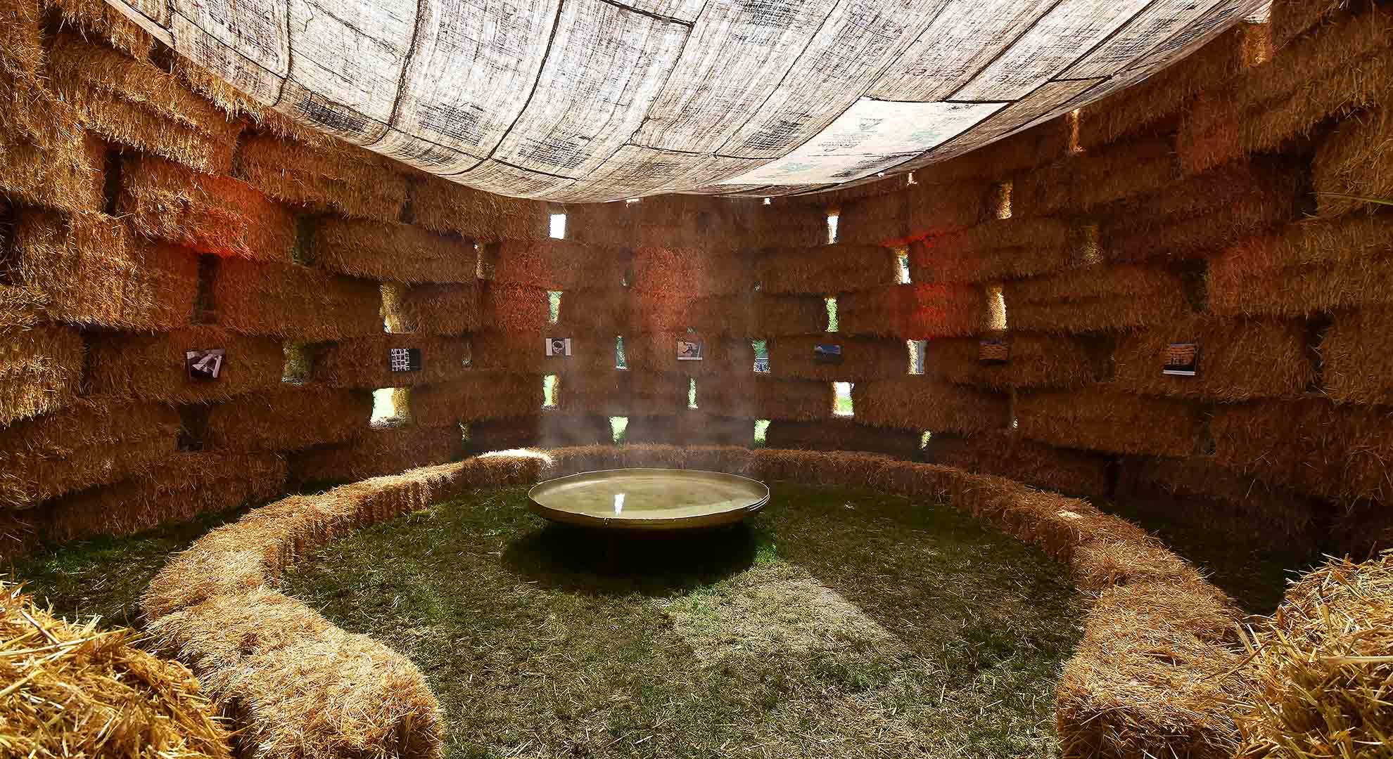 Espacio circular construido con fardos de paja, en el que se fusionan arquitectura y sostenibilidad a través de materiales naturales y diseño ecológico.
