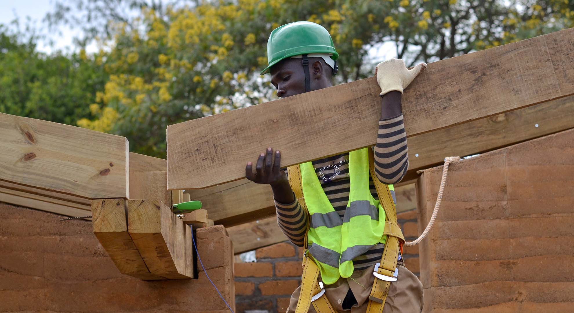 Installation of locally sourced timber beams at the Rwanda Institute for Conservation Agriculture, MASS Design Group. Photo © MASS Design Group